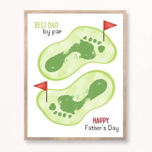 May include: A framed print with a Father's Day theme. The artwork features two green golf course footprints with red flags, and the text "BEST DAD by par" and "HAPPY Father's Day" in green and red.