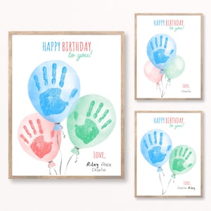 Peut inclure: Ensemble de trois impressions encadrées sur le thème de l'anniversaire. Chaque impression présente des ballons aquarelles bleus, verts et roses, avec des empreintes de mains à l'intérieur. Le texte dit "Happy Birthday to you!" et "Love, Riley Alex Charlie."