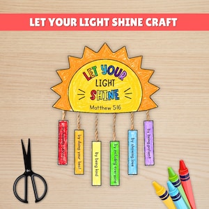 Può includere: Un progetto artigianale con un ritaglio a forma di sole che recita "Let Your Light Shine" con il versetto biblico Matteo 5:16. Il sole ha rettangoli appesi con frasi come "aiutando gli altri" e "essendo gentili". Sono presenti anche forbici e pastelli.