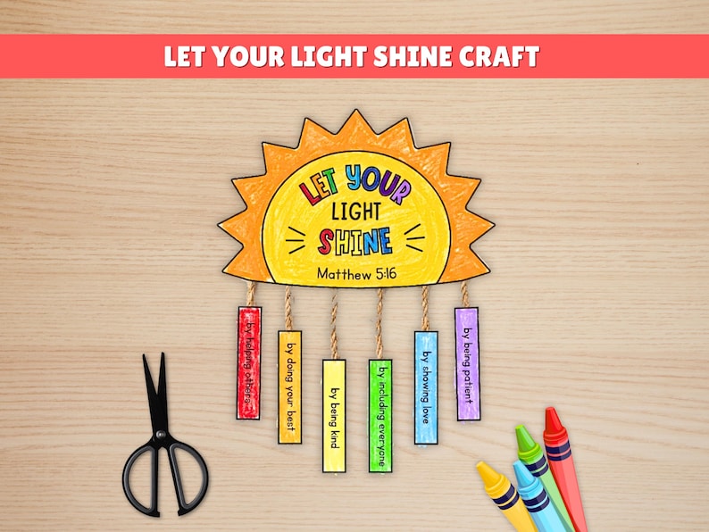 May include: A craft project with a sun-shaped cutout that reads "Let Your Light Shine" with the Bible verse Matthew 5:16. The sun has hanging rectangles with phrases like "by helping others" and "by being kind." Scissors and crayons are also present.