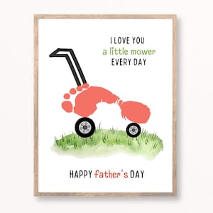 May include: A framed print with a lawnmower design made from a child's footprint in coral. The lawnmower has black wheels and handle, set against a watercolor grass background. Text reads "I love you a little mower every day" and "Happy father's day."