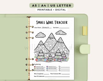 May include: A printable Small Wins Tracker page in a light green binder. The page features a mountain and tree graphic with circles to color, a My Win Key section with colored dots, and lines for tracking wins, dates, and celebration plans.