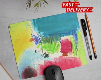 Può includere: Un colorato tappetino per mouse con un design astratto nei toni del giallo, blu, verde e rosso. Un mouse per computer nero, una penna nera e una matita sono accanto al tappetino per mouse. Le parole "FAST DELIVERY" sono in rosso.