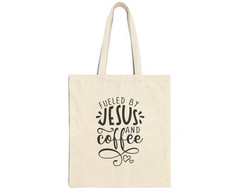 May include: A beige tote bag with black text that reads "Fueled by Jesus and coffee" with a small heart design.