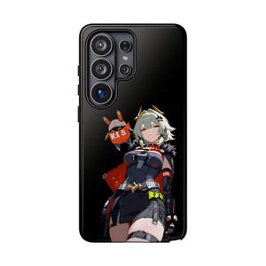 Puede incluir: Funda de teléfono negra con una colorida ilustración de estilo anime de un personaje femenino con cabello verde y una capa roja. La funda tiene un acabado brillante y un recorte para la cámara.