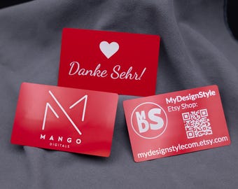 Spersonalizowana metalowa wizytówka aluminiowa w kolorze czerwonym, grawerowana laserowo imieniem, logo, grafiką i kodem QR.