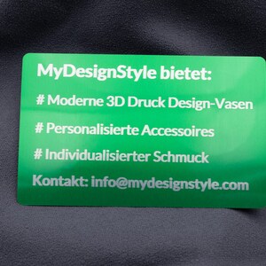 Grüne Visitenkarte aus Metall mit lasergraviertem Text: moderne 3D-Druck Design-Vasen, personalisierte Accessoires und individualisierter Schmuck. Der edle Glanz der Aluminiumoberfläche verleiht der Karte Hochwertigkeit und Einzigartigkeit. Ideal für Firmen, die ihr Angebot stilvoll präsentieren und durch außergewöhnliche Businesskarten einen bleibenden Eindruck hinterlassen möchten.