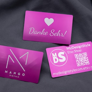 Könnte beinhalten: Drei magentafarbene Visitenkarten mit weißem Text und Logos. Eine Karte hat ein Herz und die Worte "Danke Sehr!". Eine andere hat das "M1"-Logo und "Mango Digitals". Die dritte Karte enthält Etsy-Shop-Informationen.