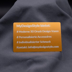 Hellgoldene Aluminiumkarte mit Gravur der MyDesignStyle-Angebote: moderne 3D-Druck Vasen, personalisierte Accessoires und individualisierter Schmuck. Zusätzlich mit Kontakt-E-Mail versehen. Die gravierte Metallkarte vereint Werbewirkung mit hochwertigem Design und eignet sich perfekt als elegante Informationskarte, Beileger oder Präsentationskarte für Online-Shops.