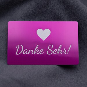 Stilvolle Visitenkarte aus Aluminium in kräftigem Lila mit lasergraviertem Herzsymbol und der Aufschrift „Danke Sehr!“. Die metallische Oberfläche glänzt edel und sorgt für einen besonderen Eindruck. Diese Karte eignet sich hervorragend als Beileger in Bestellungen, als Dankeschön an Kunden oder als besondere Geste im geschäftlichen und privaten Bereich. Robustes Aluminium macht sie langlebig und wiederverwendbar.