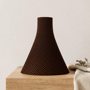 Peut inclure: Un vase brun en forme de c&ocirc;ne avec un motif textur&eacute; en treillis. Le vase est pos&eacute; sur une surface en bois de couleur claire. Le design est moderne et minimaliste, adapt&eacute; &agrave; la d&eacute;coration int&eacute;rieure.