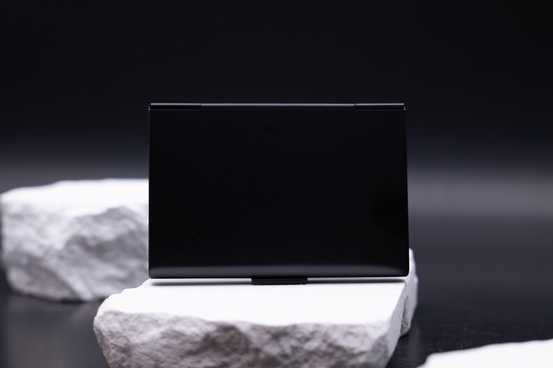 Schlichte Rückseite eines schwarzen Metall-Visitenkartenetuis ohne Gravur. Das minimalistische, leichte Design überzeugt durch Eleganz und Robustheit. Ideal für Männer und Frauen im Business-Bereich, die Karten sicher aufbewahren wollen. Es schützt zuverlässig vor Knicken und passt perfekt in jede Tasche. Ein modernes Accessoire für Meetings, Büro und Business-Events.