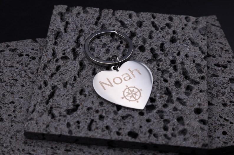 Personalisierter Schlüsselanhänger aus Edelstahl in Herzform, graviert mit dem Namen „Noah“ und Kompasssymbol. Die glänzende Oberfläche und das schlichte Design machen den Anhänger zu einem eleganten Accessoire am Schlüsselbund. Er symbolisiert Orientierung und Liebe – perfekt als individuelles Geschenk zum Valentinstag, Geburtstag oder Jubiläum.