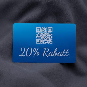 Exklusive Rabattkarte aus Aluminium in Blau mit Gravur „20% Rabatt“ und integriertem QR-Code. Die edle Metalloberfläche mit matter Struktur und die abgerundeten Kanten verleihen der Karte ein hochwertiges Erscheinungsbild. Sie eignet sich perfekt als modernes Marketinginstrument für Aktionen, Kundenprogramme oder Events und hebt sich durch ihre Stabilität und Wiederverwendbarkeit von herkömmlichen Werbekarten ab.
