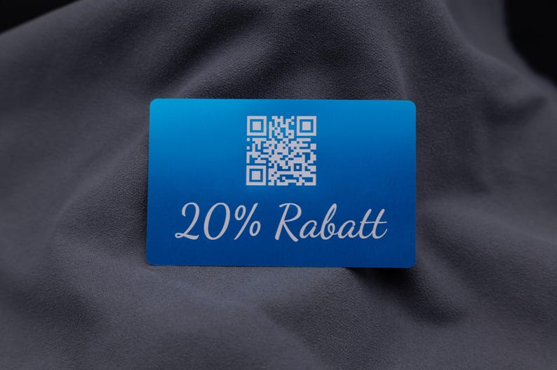 Exklusive Rabattkarte aus Aluminium in Blau mit Gravur „20% Rabatt“ und integriertem QR-Code. Die edle Metalloberfläche mit matter Struktur und die abgerundeten Kanten verleihen der Karte ein hochwertiges Erscheinungsbild. Sie eignet sich perfekt als modernes Marketinginstrument für Aktionen, Kundenprogramme oder Events und hebt sich durch ihre Stabilität und Wiederverwendbarkeit von herkömmlichen Werbekarten ab.