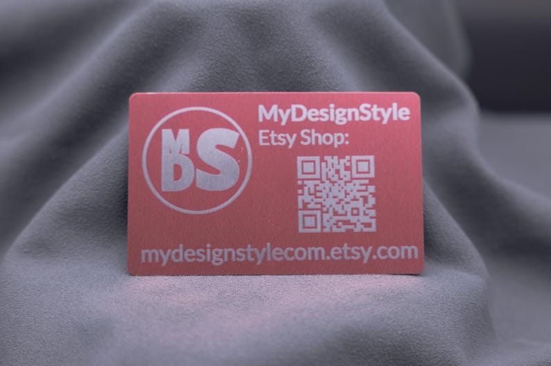 Einzelne roségoldene Aluminiumkarte mit Gravur des MDS-Logos, Etsy-Shop-Adresse und QR-Code. Die matte Oberfläche wirkt hochwertig und modern, die Karte ist stabil und langlebig. Ideal für Branding, Networking und kreative Businessideen. Eine edle Alternative zur klassischen Papierkarte für Unternehmer und Designer.