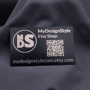 Visitenkarte aus schwarzem Aluminium mit Gravur „MDS“ Logo, Etsy-Shop-URL und QR-Code. Die stabile Metallkarte ist modern, elegant und ideal für Branding, Marketing und als langlebige Businesskarte mit individueller Gravur.