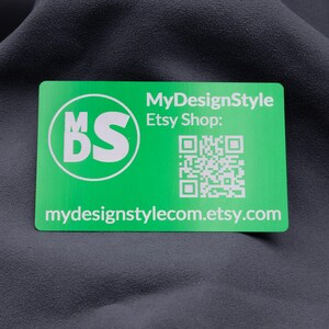 Grüne Aluminium-Visitenkarte mit dem Logo "MDS", einem QR-Code und Etsy-Shop-Link. Das klare weiße Gravurdesign auf der glänzenden Oberfläche sorgt für ein modernes und professionelles Erscheinungsbild. Die stabile Karte ist langlebig und praktisch, ideal zur Weitergabe an Kunden, die direkten Zugriff auf den Onlineshop erhalten und gleichzeitig ein exklusives Design in den Händen halten.