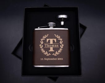 Elegante set de regalo de petaca personalizado con nombre y monograma, fabricado en acero inoxidable. Incluye también piel sintética vegana marrón con grabado dorado.