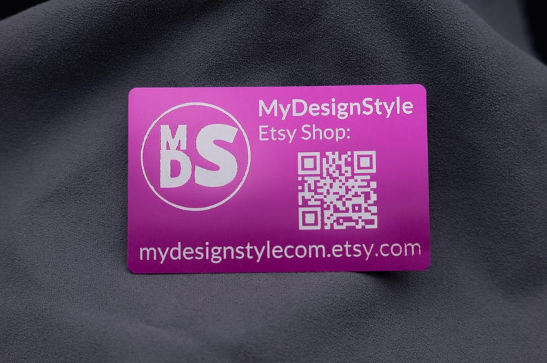 Aluminium-Visitenkarte in Lila mit MyDesignStyle-Logo, Etsy-Shop QR-Code und Webadresse. Das Design ist klar und modern, perfekt für Markenaufbau und Kundenkommunikation. Durch die stabile Metalloberfläche hebt sich diese Karte von klassischen Papierkarten ab und wirkt besonders hochwertig. Mit dem QR-Code können Kunden direkt den Shop aufrufen – eine moderne und funktionale Businesskarte.