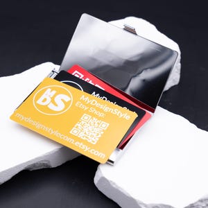 Größenvergleich von Leichtes Visitenkartenetui Metall silber aus Metall. Diese Aufnahme passt zum Suchwort Kartenetui geschenk aus dem MyDesignStyle Sortiment. Praktisch und stilvoll als Personalisiertes etui im Alltag. Weitere Motive zum Thema Visitenkarten halter bei MyDesignStyle entdecken.