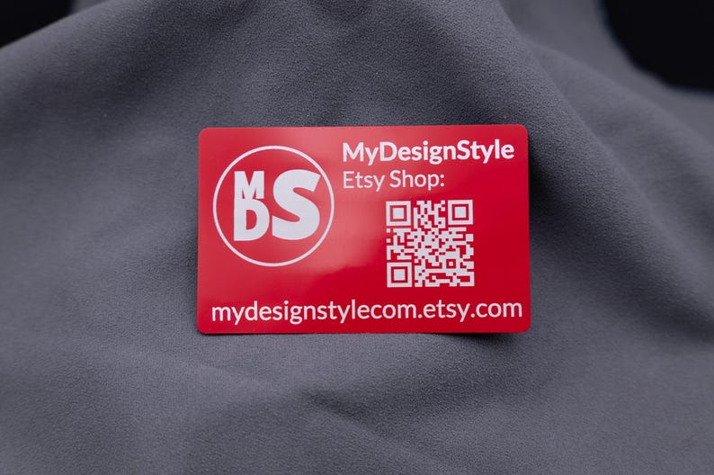 Visitenkarte aus rotem Aluminium mit eingraviertem MDS-Logo, Etsy-Shop-Adresse und QR-Code. Die matte Metallkarte ist langlebig, robust und modern – perfekt für Branding, Marketing und kreative Businessideen. Eine edle Alternative zu klassischen Papierkarten, ideal für professionelle Unternehmenspräsentationen.