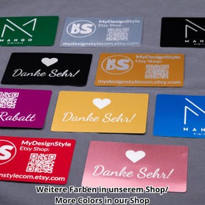 Übersicht mehrerer Aluminium-Visitenkarten in unterschiedlichen Farben wie Schwarz, Silber, Gold, Grün, Blau, Rot und Lila. Die Karten zeigen verschiedene Gravuren, darunter Herzmotive, Logos, QR-Codes und Schriftzüge wie „Danke Sehr“ oder Rabattaktionen. Jede Karte ist aus stabilem Aluminium gefertigt, mit präziser Lasergravur versehen und ideal für Firmen, Branding, Danksagungen oder kreative Geschenkideen.