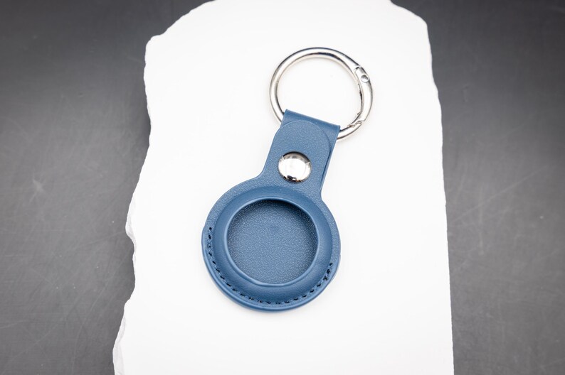 Rückseite eines blauen AirTag Schlüsselanhängers aus PU Leder ohne Gravur. Die runde Form ist exakt auf den Apple AirTag abgestimmt. Saubere Nähte und robuster Edelstahlring sorgen für Langlebigkeit. Praktisches Zubehör zur sicheren Befestigung von AirTags an Schlüsseln Rucksack oder Tasche.