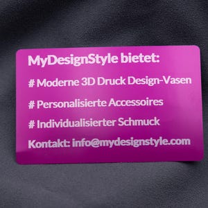 Elegante Visitenkarte aus Aluminium in Metallic-Lila mit Gravur der Angebote von MyDesignStyle: 3D Druck Design-Vasen, personalisierte Accessoires und individueller Schmuck. Zusätzlich ist die Kontaktadresse eingraviert. Die Karte kombiniert stilvolles Design mit praktischer Information und bleibt durch die Aluminium-Oberfläche besonders langlebig. Ideal für Unternehmen, die modernes Design mit Funktion verbinden möchten.