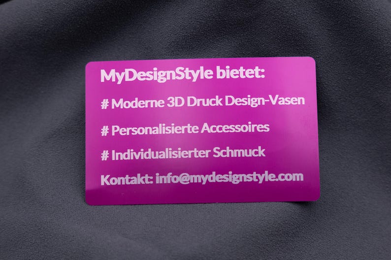 Elegante Visitenkarte aus Aluminium in Metallic-Lila mit Gravur der Angebote von MyDesignStyle: 3D Druck Design-Vasen, personalisierte Accessoires und individueller Schmuck. Zusätzlich ist die Kontaktadresse eingraviert. Die Karte kombiniert stilvolles Design mit praktischer Information und bleibt durch die Aluminium-Oberfläche besonders langlebig. Ideal für Unternehmen, die modernes Design mit Funktion verbinden möchten.