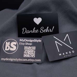 Op de afbeelding: Drie zwarte visitekaartjes met witte tekst en logo's. Eén kaart zegt "Danke Sehr!" met een hart. Een andere heeft een logo en "MyDesignStyle Etsy Shop: mydesignstylecom.etsy.com". De derde kaart zegt "MANGO DIGITALS".