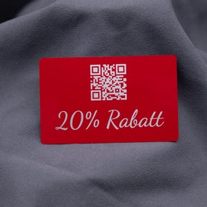 Exklusive Rabattkarte aus rotem Aluminium mit Gravur „20% Rabatt“ und QR-Code. Das moderne Design auf langlebiger Metalloberfläche wirkt edel und stabil. Ideal als Gutscheinkarte, Rabattkarte oder auffälliges Werbemittel für Unternehmen, die Kunden mit einer hochwertigen Alternative zu Papierkarten überraschen möchten.