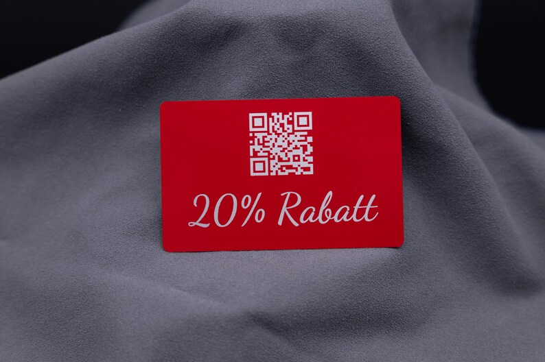 Exklusive Rabattkarte aus rotem Aluminium mit Gravur „20% Rabatt“ und QR-Code. Das moderne Design auf langlebiger Metalloberfläche wirkt edel und stabil. Ideal als Gutscheinkarte, Rabattkarte oder auffälliges Werbemittel für Unternehmen, die Kunden mit einer hochwertigen Alternative zu Papierkarten überraschen möchten.