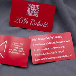 Drei rote Aluminiumkarten mit Gravur. Oben eine Rabattkarte mit QR-Code und Gravur „20% Rabatt“, unten links eine Businesskarte mit Mango-Logo und Kontaktdaten, daneben eine Karte mit Produktübersicht: 3D-Druck-Designvasen, personalisierte Accessoires, individueller Schmuck. Die edlen Metallkarten sind robust, langlebig und ein stilvolles Marketing- und Businessinstrument.
