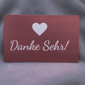 Dankeskarte aus roségoldenem Aluminium mit Herzsymbol und Gravur „Danke Sehr!“. Die matte Metalloberfläche wirkt stilvoll und elegant, die Karte ist langlebig und robust. Perfekt als exklusive Dankeskarte für Kunden, Partner oder besondere Anlässe – eine moderne Alternative zu Papierkarten im Premium-Look.