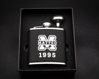 Elegante set de regalo de petaca personalizado con nombre y monograma, fabricado en acero inoxidable. Incluye también piel sintética vegana negra con grabado plateado.