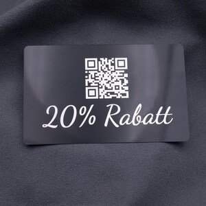 Rabattkarte aus schwarzem Aluminium mit Gravur „20% Rabatt“ und QR-Code. Robuste, langlebige Metallkarte mit edlem, modernem Look, ideal als Werbekarte, Gutscheinkarte oder exklusives Marketinginstrument. Die Karte hebt sich durch Eleganz und Stabilität von herkömmlichen Papierkarten ab.
