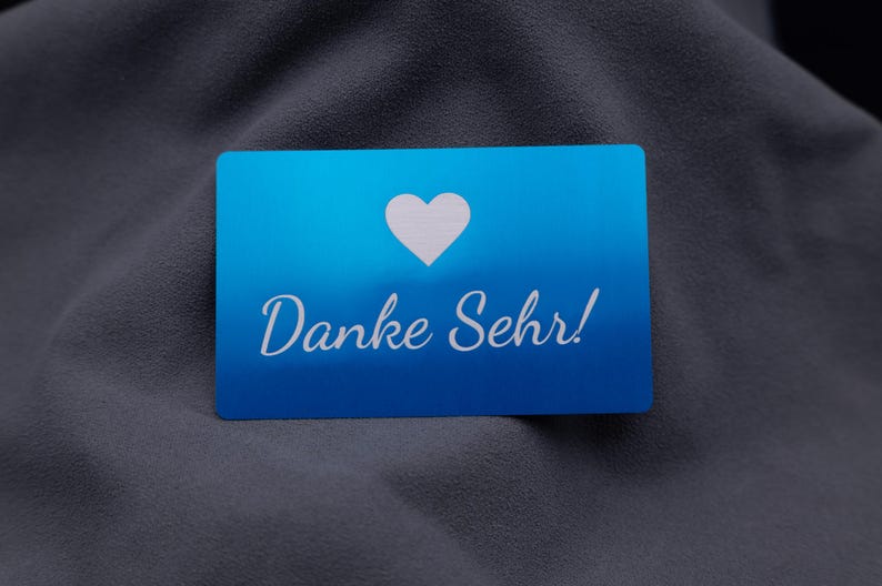 Dankeskarte aus Aluminium in elegantem Blau mit Herzsymbol und Gravur „Danke Sehr!“. Die klare Gestaltung mit matter Oberfläche und abgerundeten Ecken vermittelt Wertschätzung und Eleganz. Ideal geeignet für Unternehmen, Online-Shops oder Designer, die ihren Kunden eine persönliche Botschaft in exklusiver, langlebiger Form überreichen möchten – weit mehr als eine einfache Papierkarte.