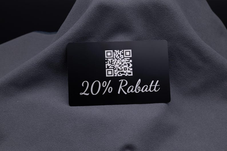 Visitenkarte aus Aluminium in Schwarz mit Gravur „20% Rabatt“ und QR-Code. Die langlebige Metallkarte eignet sich ideal als exklusive Rabattkarte oder Werbekarte, die bei Kunden durch stilvolles Design und hochwertige Haptik Eindruck hinterlässt.