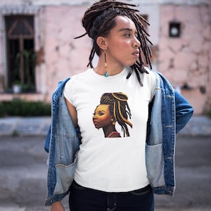Könnte beinhalten: Weißes T-Shirt mit einem Seitenprofil-Porträt einer Frau mit Dreadlocks und goldenen Akzenten. Die Frau trägt ein rotes Oberteil. Die Person auf dem Bild trägt eine Jeansjacke und eine dunkelblaue Jeans.