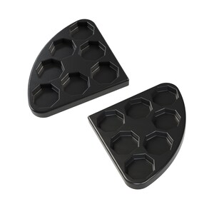 May include: Two black, semi-circular trays with multiple hexagonal indentations. The trays are made of a matte material and are designed to hold small items. The trays are shown against a white background.