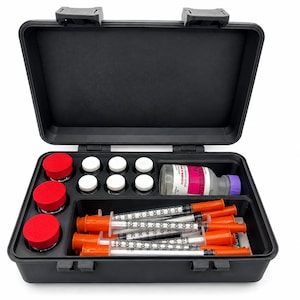 May include: A black plastic carrying case containing three small jars with red lids, six small clear vials with white caps, one larger clear bottle with a purple cap and a label, and five clear plastic syringes with orange caps and plungers.
