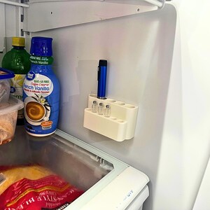 Fridge storage setup with GLP-1 and insulin pen organizer mounted on wall, space saving peptide vial holder keeping injection supplies neat, organized, and out of the way inside refrigerator