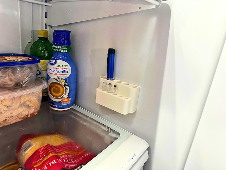 Fridge storage setup with GLP-1 and insulin pen organizer mounted on wall, space saving peptide vial holder keeping injection supplies neat, organized, and out of the way inside refrigerator