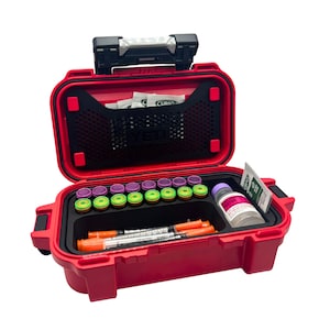 May include: A red hard-shell storage case with a black handle and latch, featuring a YETI logo on the interior mesh pocket. The case contains a row of small vials with purple and green caps, two syringes with orange caps, and a bottle of Bacteriostatic Water.