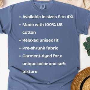K&ouml;nnte beinhalten: Ein staubblaues T-Shirt mit dem Text: "Erh&auml;ltlich in den Gr&ouml;&szlig;en S bis 4XL, Hergestellt aus 100 % US-Baumwolle, Entspannte Unisex-Passform, Vorgeschrumpfter Stoff, Kleidungsst&uuml;ckgef&auml;rbt f&uuml;r eine einzigartige Farbe und weiche Textur."