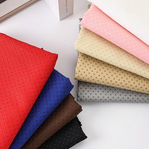 May include: A selection of colourful non-slip fabric sheets in red, blue, brown, and black, with a dotted texture. Additional sheets in pink, beige, grey, and white are also visible. These sheets are likely used for crafting or household projects.