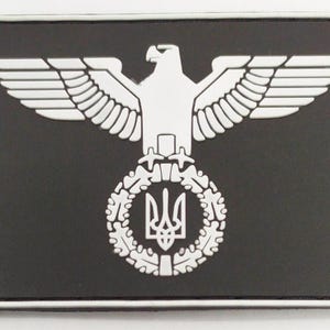 Peut inclure: Un patch noir avec un aigle blanc aux ailes déployées, une couronne de feuilles de chêne et un trident au centre.