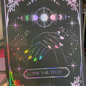 May include: Black print with iridescent foil accents featuring celestial and nail art designs. The image includes hands with colourful manicured nails, stars, moons, and the text "THE NAIL TECH" in a decorative frame.