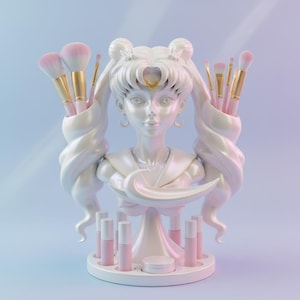 May include: A white bust-shaped makeup organizer with long, flowing hair and a crescent moon detail. It holds pink makeup brushes with gold handles and pink lipsticks. The organizer is on a round base with a small container.